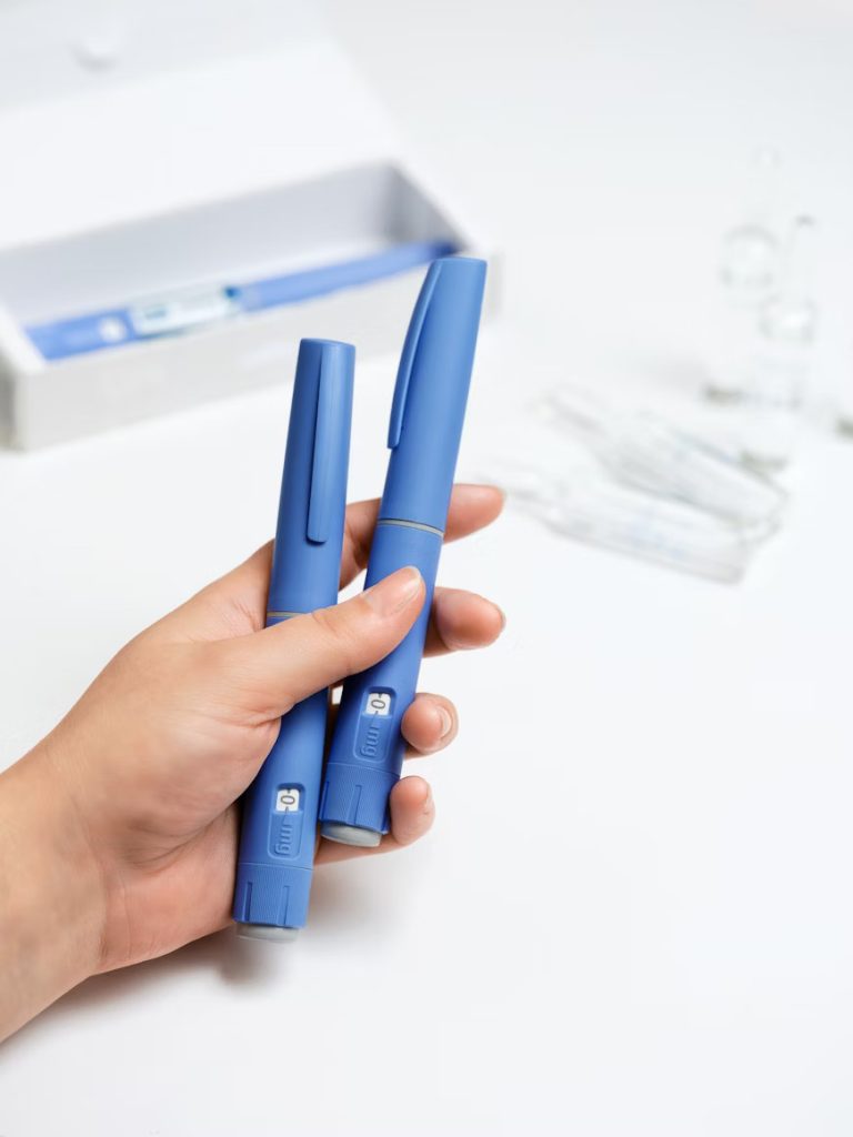 قلم انسولین آبی‌رنگ در دست بیمار دیابتی برای کنترل قند خون